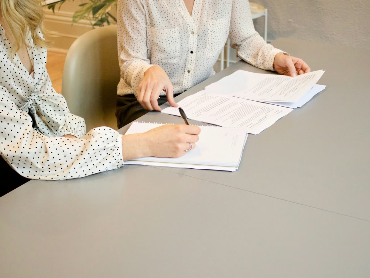 Especialista e cliente analisando documentos de um plano de consórcio